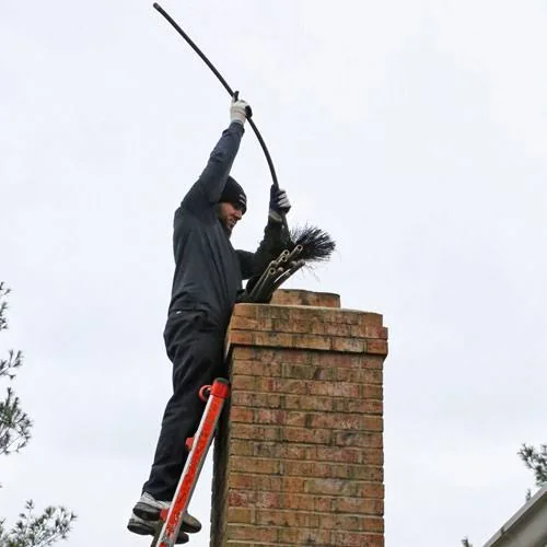 Chimney sweep cleaning a brick chimney with a brush and flexible rod from a ladder.
